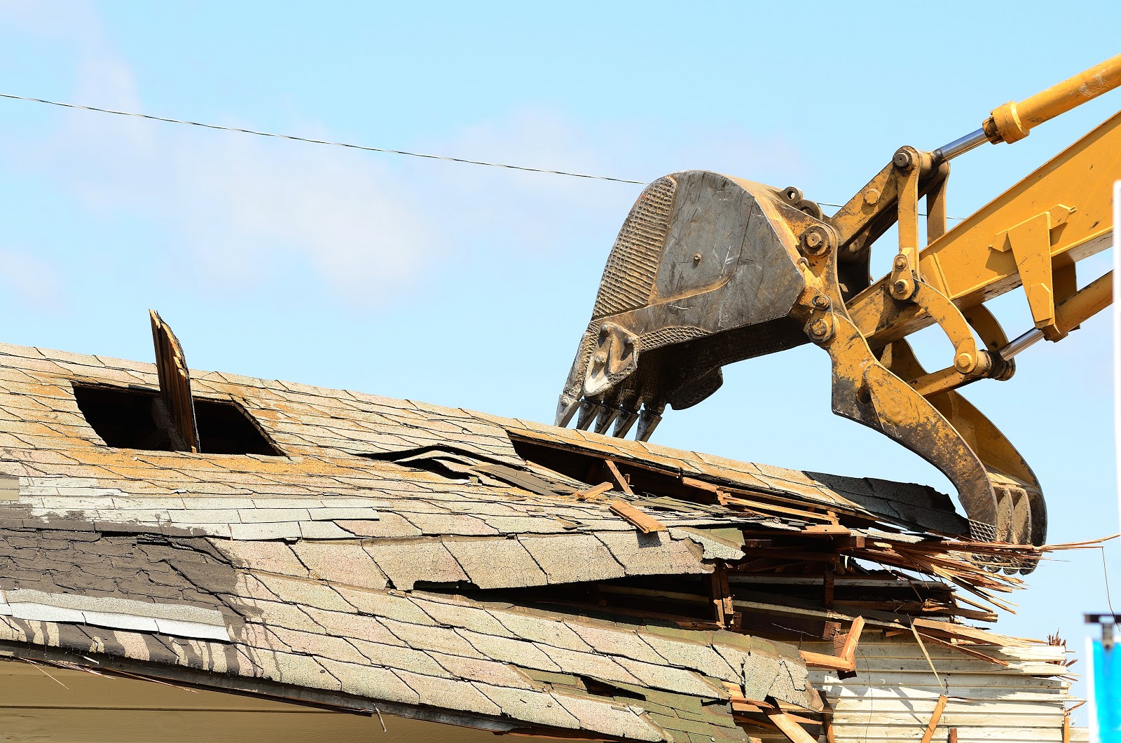 excavator ripping roof off house