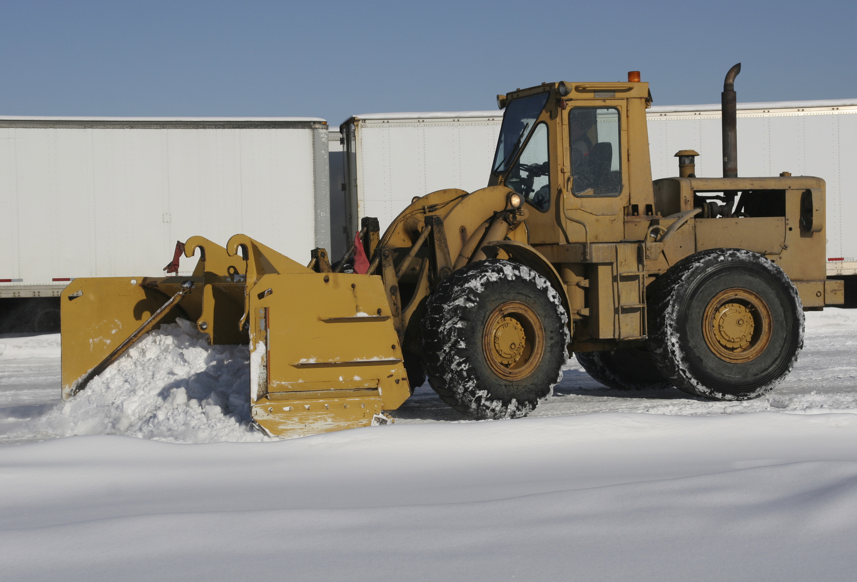 Large front end loader clearing snow after a storm